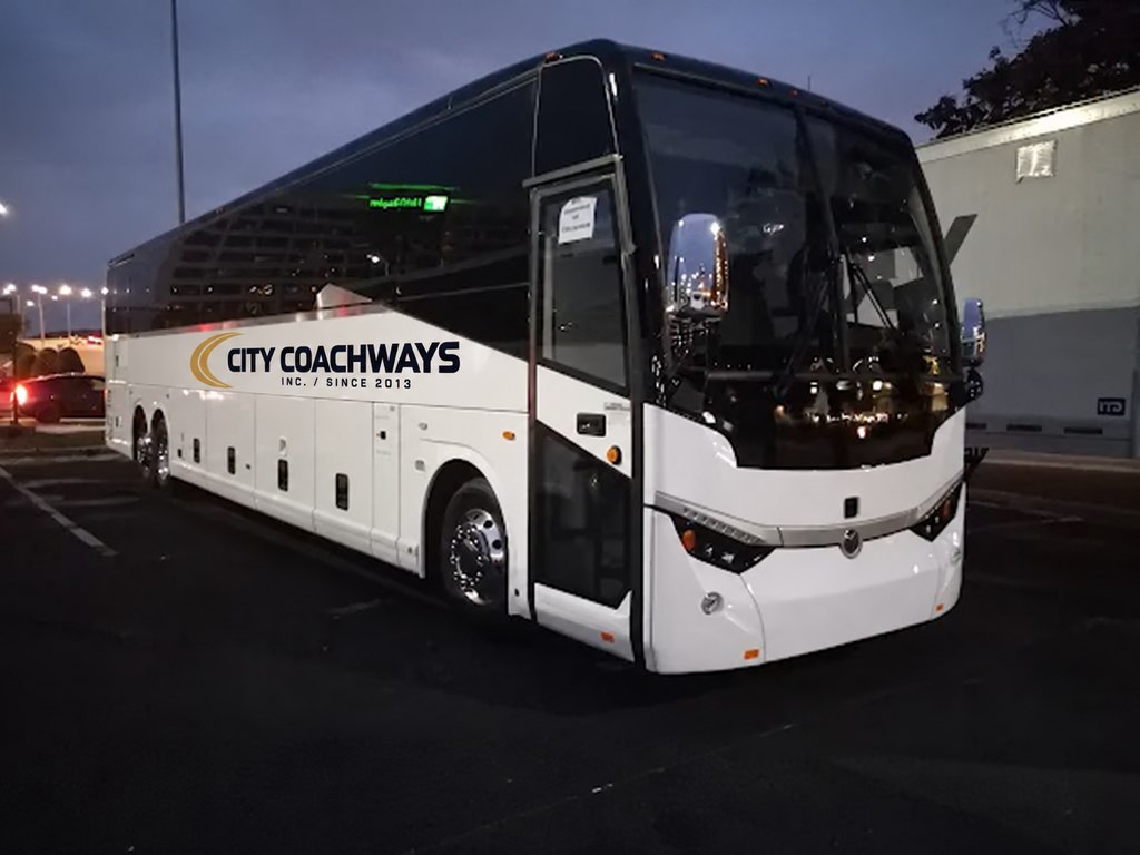 City Coachways motorcoach at dusk with gold-and-dark branding digitally applied