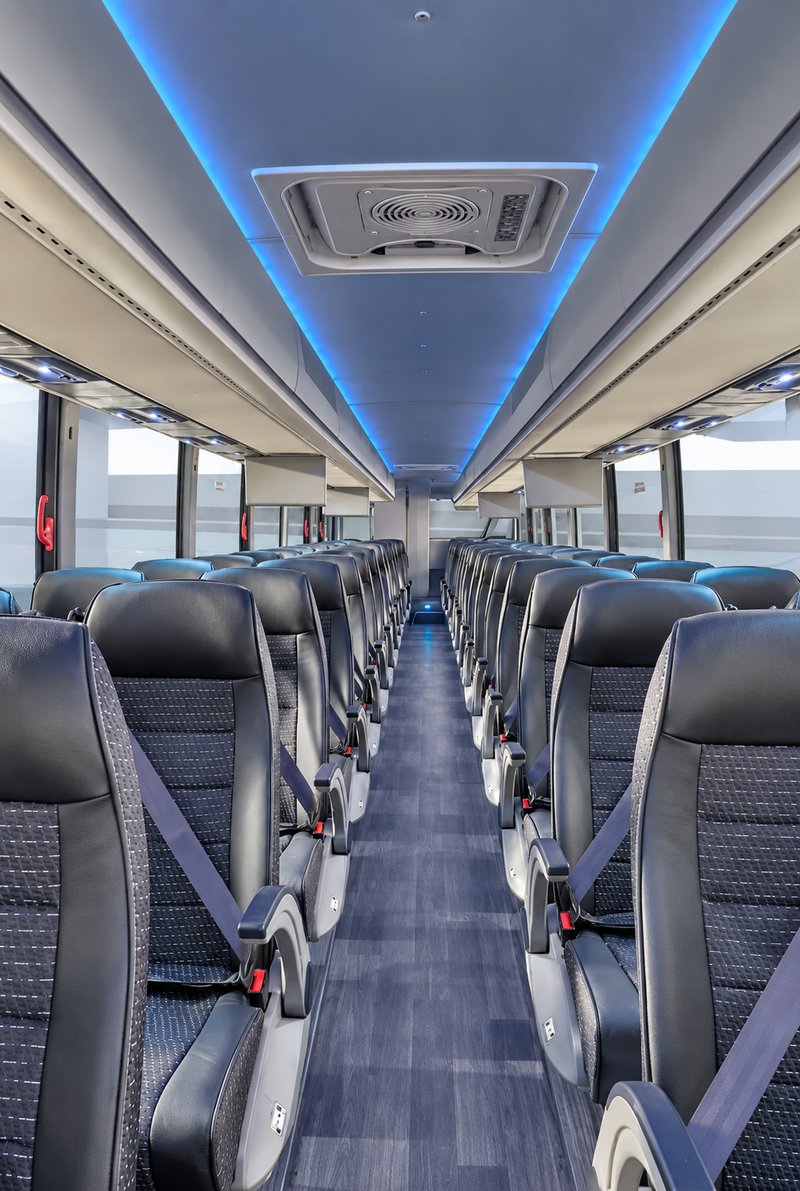 Coach aisle with belted seats and blue overhead accent lights