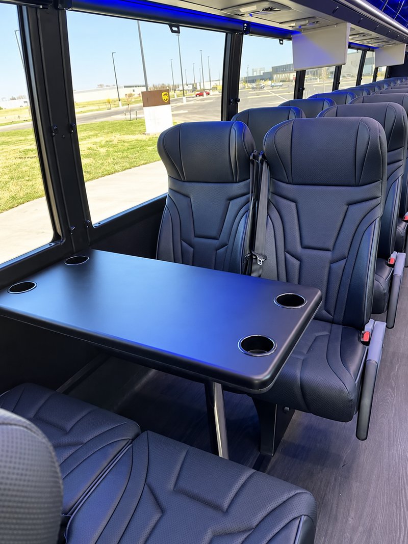 Coach table with cupholders and facing leather seats
