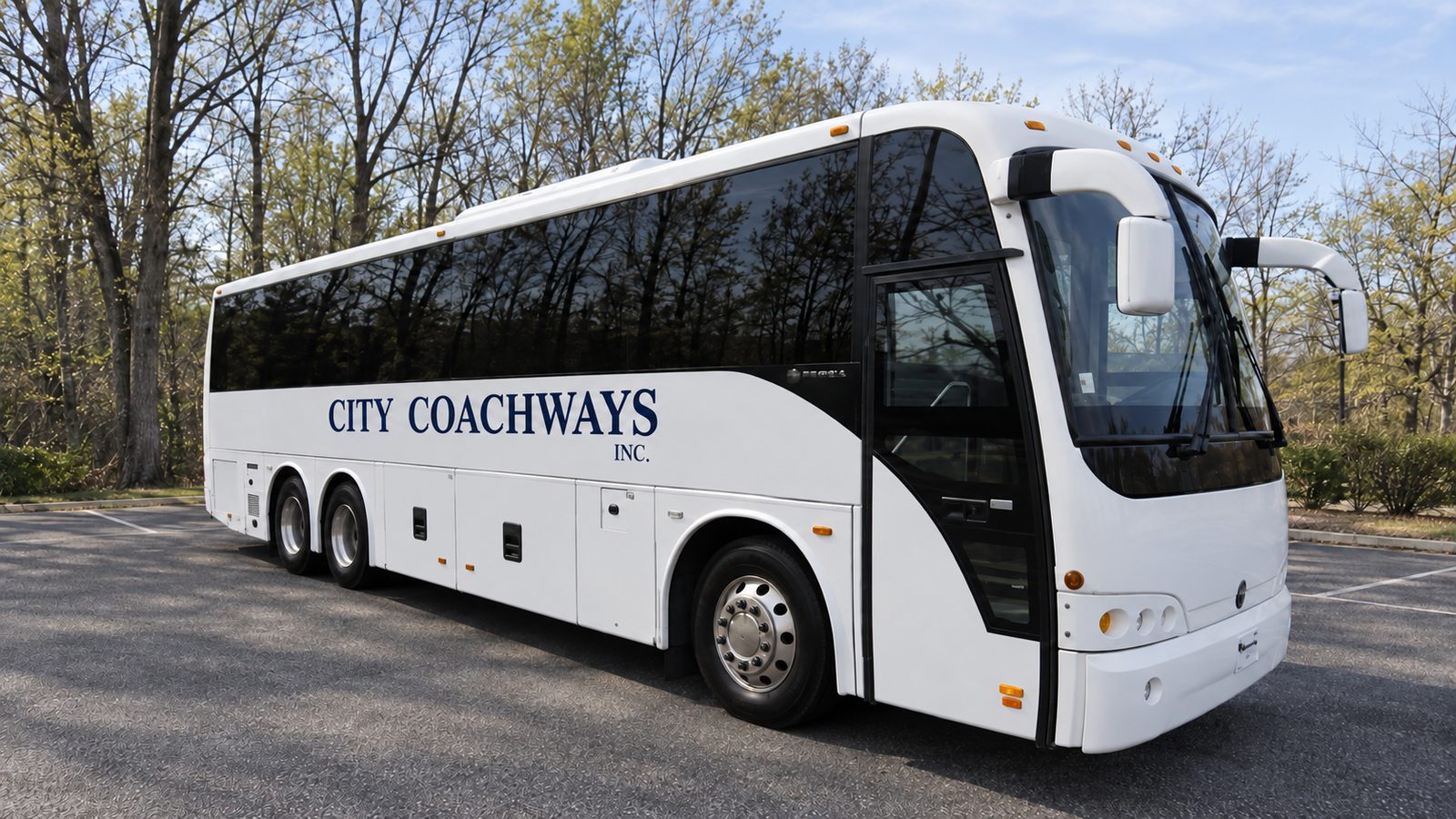 White motorcoach with dark windows, two rear axles, and City Coachways side lettering